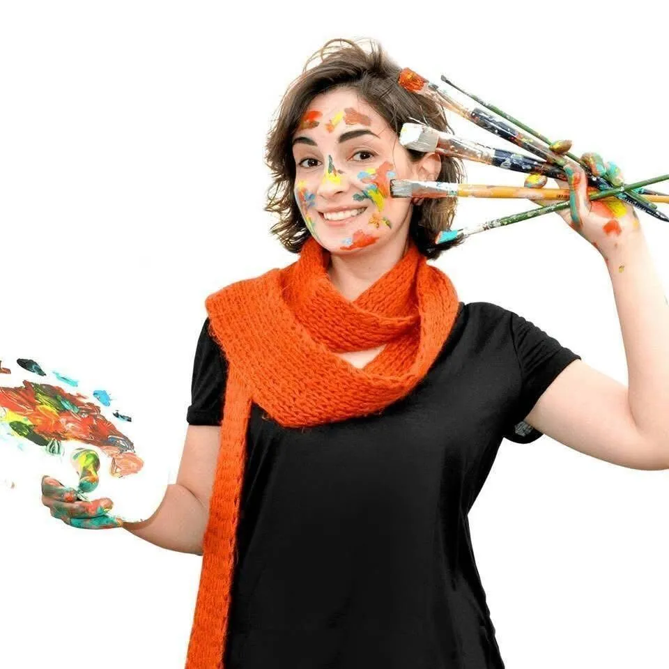 Karine Makartichan, art director and founder of Fairy Tale Publishing children's book illustration studio, holding paintbrushes